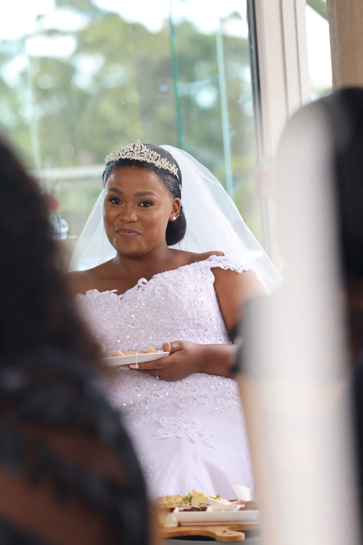 Bride with tiara and veil holding a plate at her reception